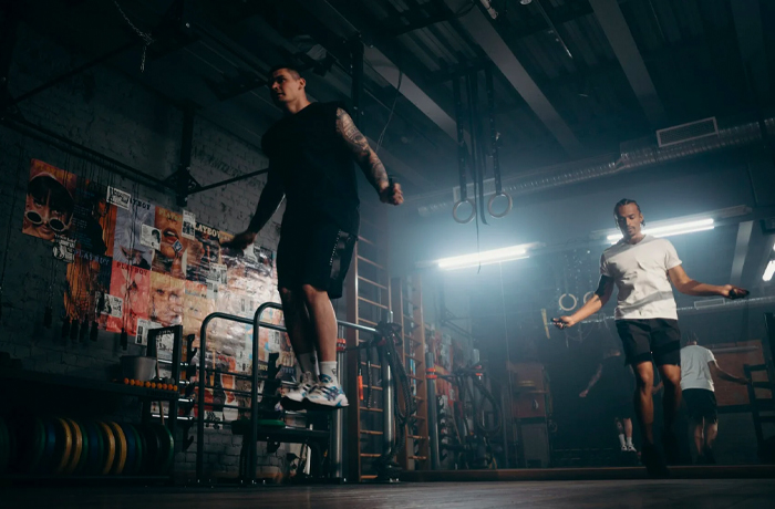Two people skipping in a dark boxing gym
